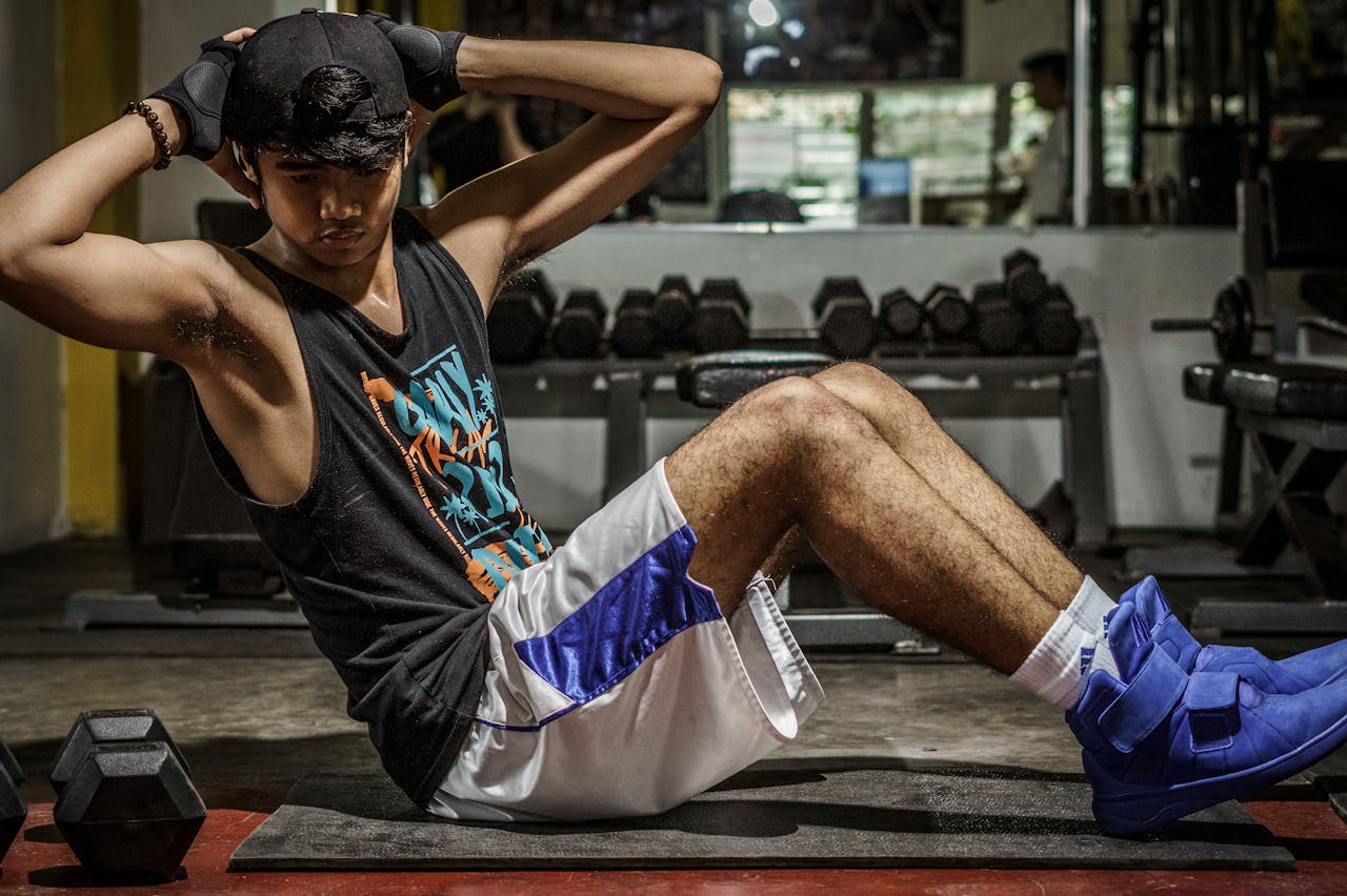 A young man performing sit-ups in a Manila gym, showcasing strength and fitness.